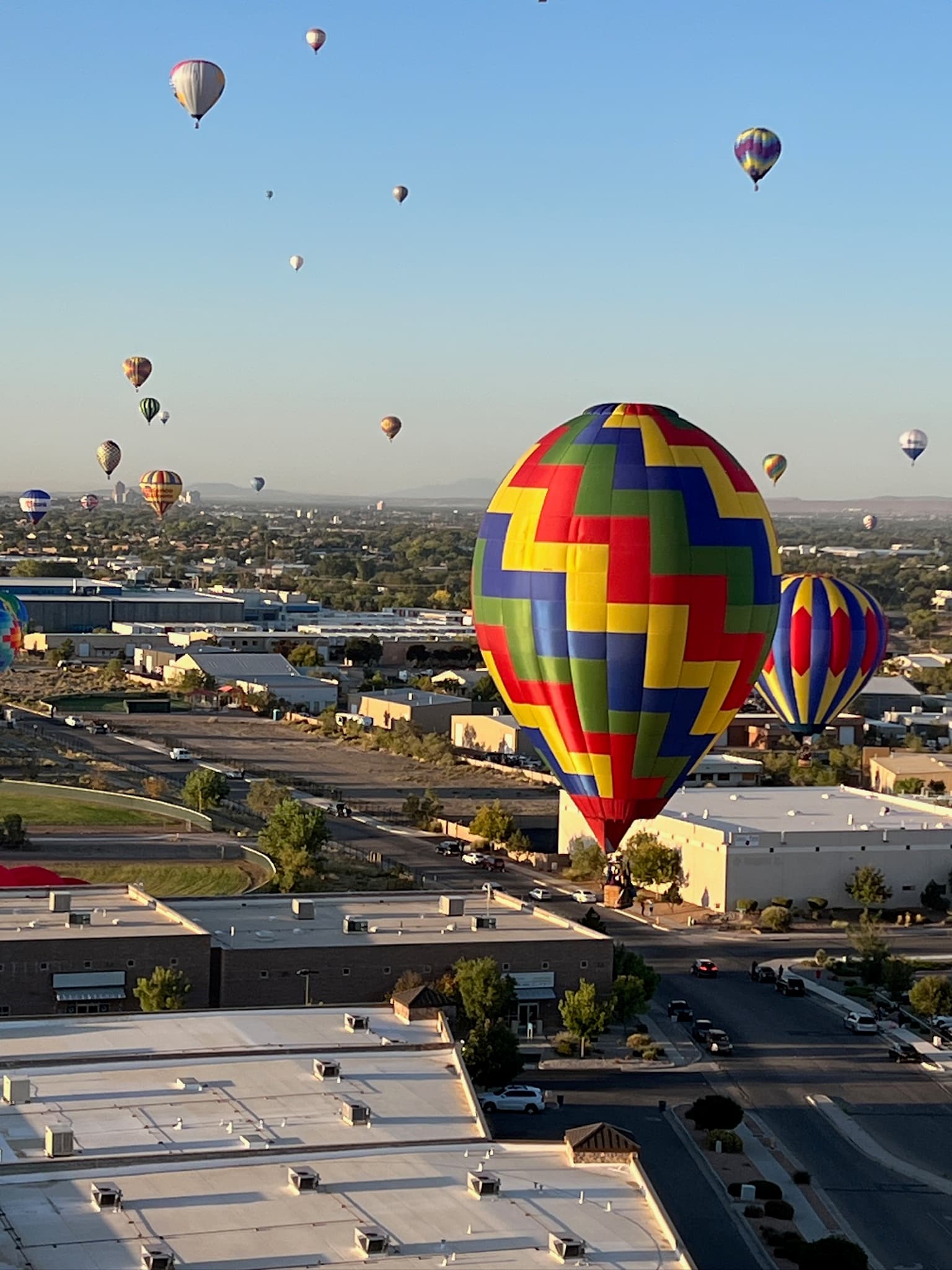 A balloon inflated on open grass beside a building